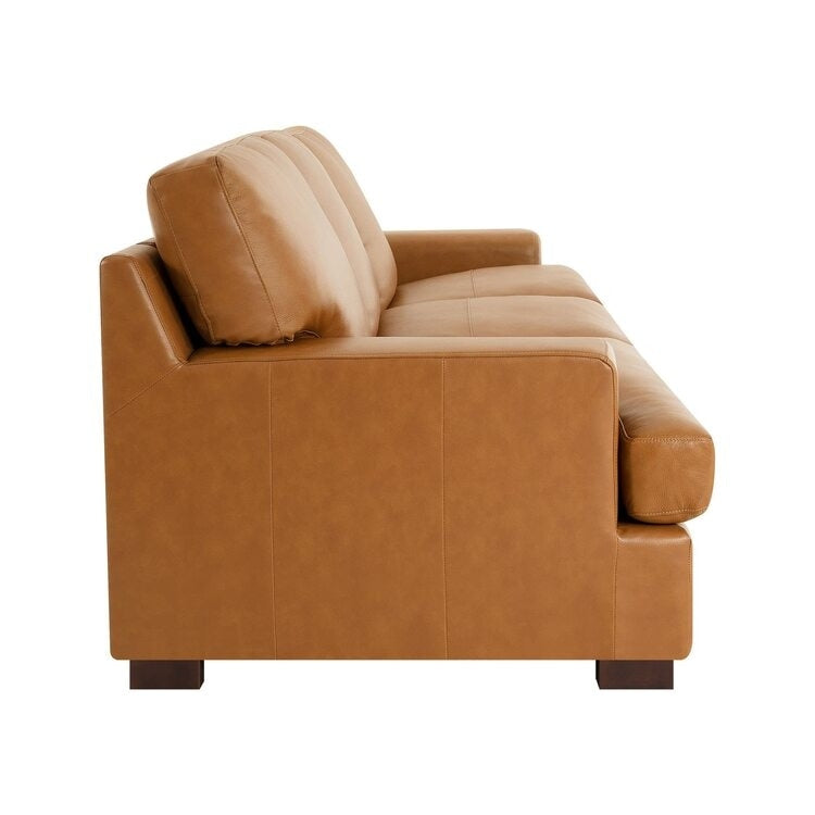 Canapé moderne en cuir véritable avec pieds en bois et coussin supplémentaire.