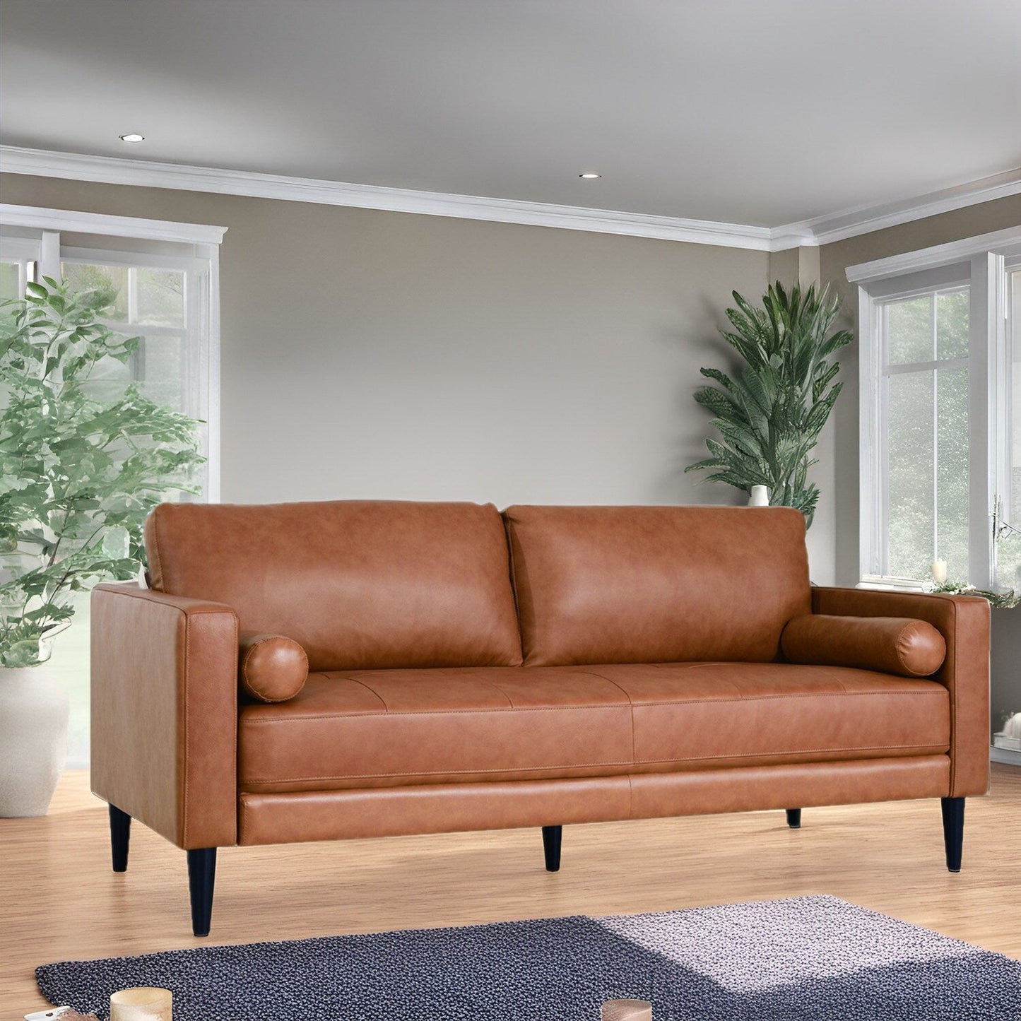 Canapé moderne en cuir véritable avec pieds en bois et coussin supplémentaire.