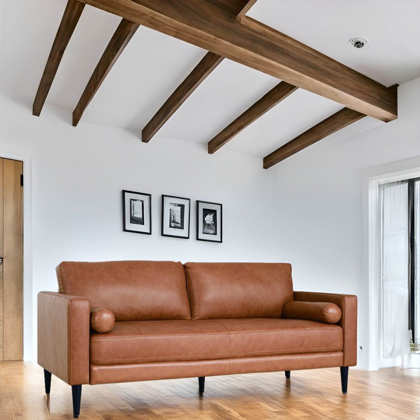 Canapé moderne en cuir véritable avec pieds en bois et coussin supplémentaire.