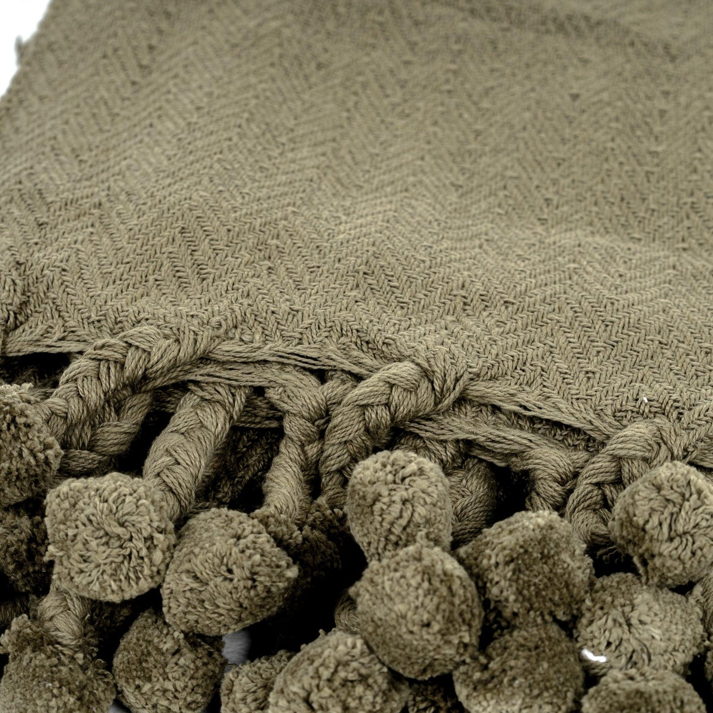 Lé pour lit en coton Vesla avec pompons tressés verts.