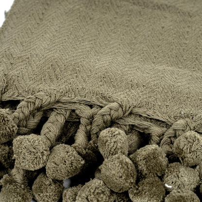 Lé pour lit en coton Vesla avec pompons tressés verts.